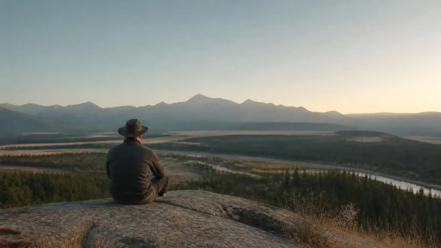 How to stop overthinking: a person sitting quietly outdoors in Alberta looking at an open landscape